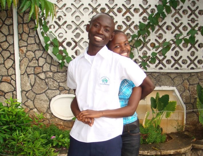 Kujali International Media - Image of two students from HOCET Secondary School, including David Focus, who celebrates his admission as the first student from HOCET Secondary School accepted to attend the University of Dar-es-Salaam.